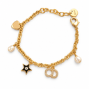 Gold-tone charm bracelet with pearl-style drops, a heart, a black star with a clear-stone centre and a stone-set letter charm. White background.